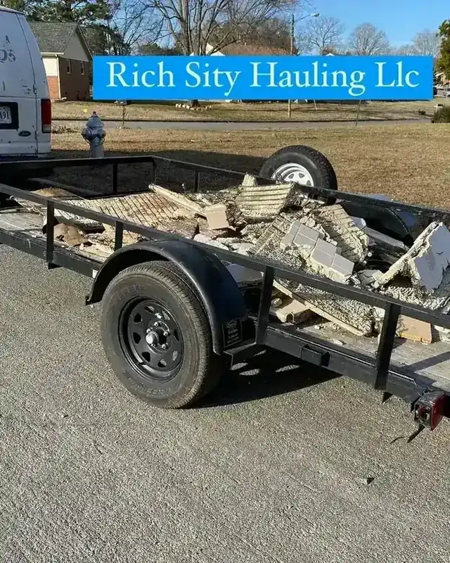 A trailer loaded with broken concrete and torn-up carpet from a renovation cleanout