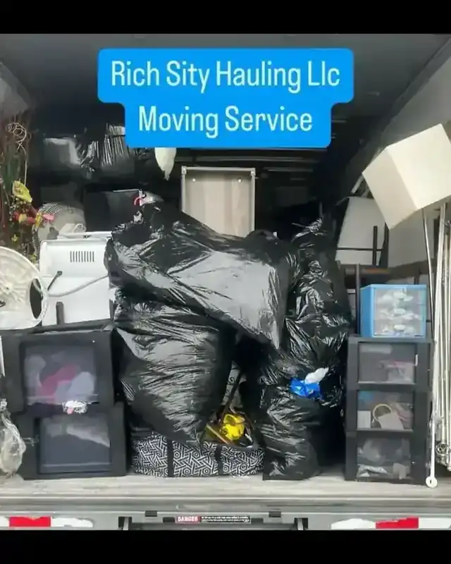 The packed interior of a Rich Sity Hauling moving truck, boxes and furniture loaded tight