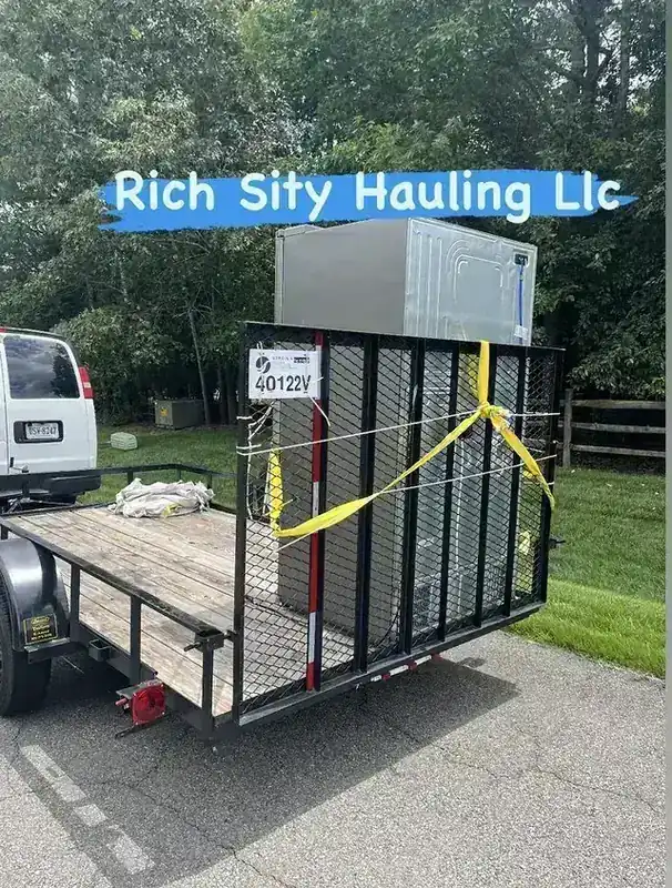 An appliance strapped upright behind the cage on the Rich Sity Hauling trailer
